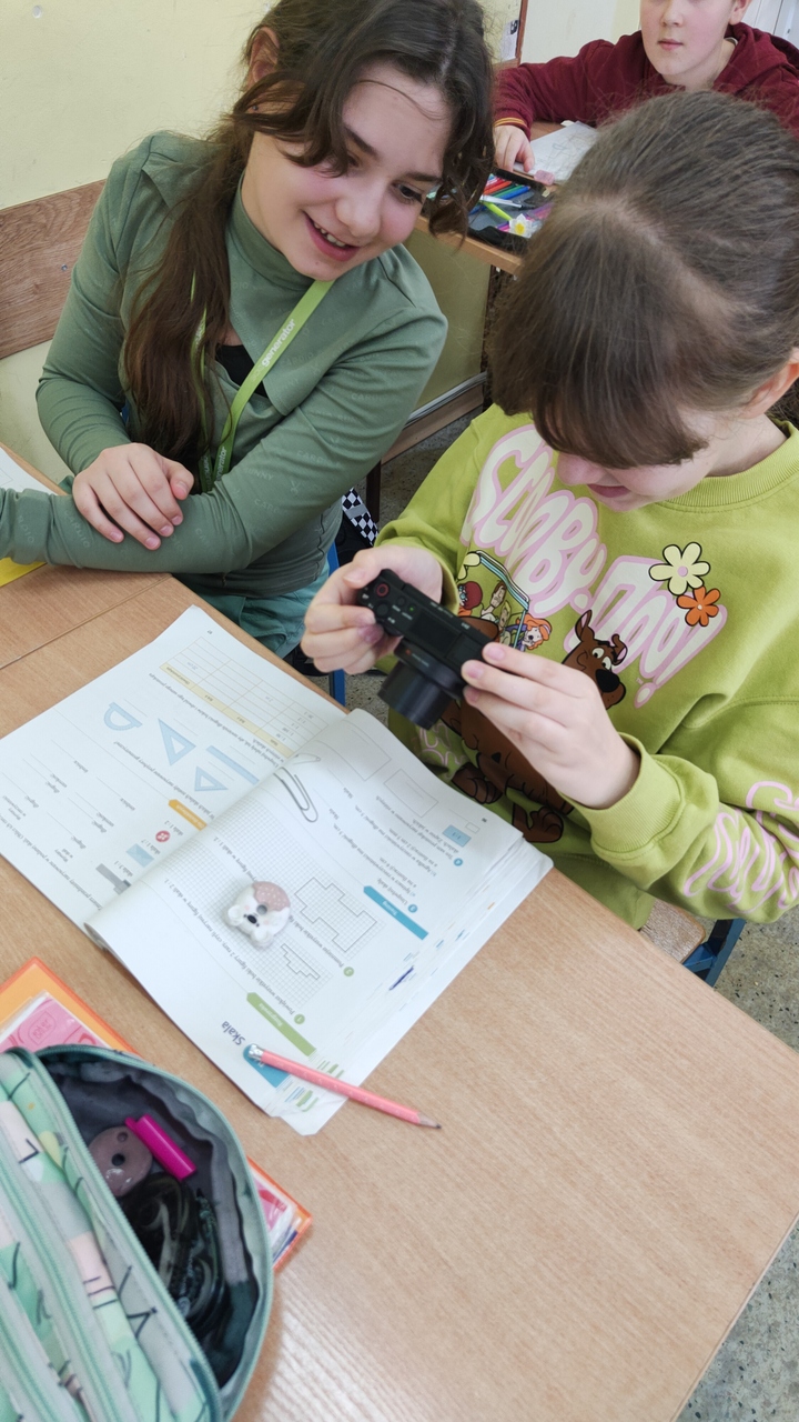 Dziewczynka i jej koleżanka robi zdjęcie gumki do zmazywania na książce od matematyki